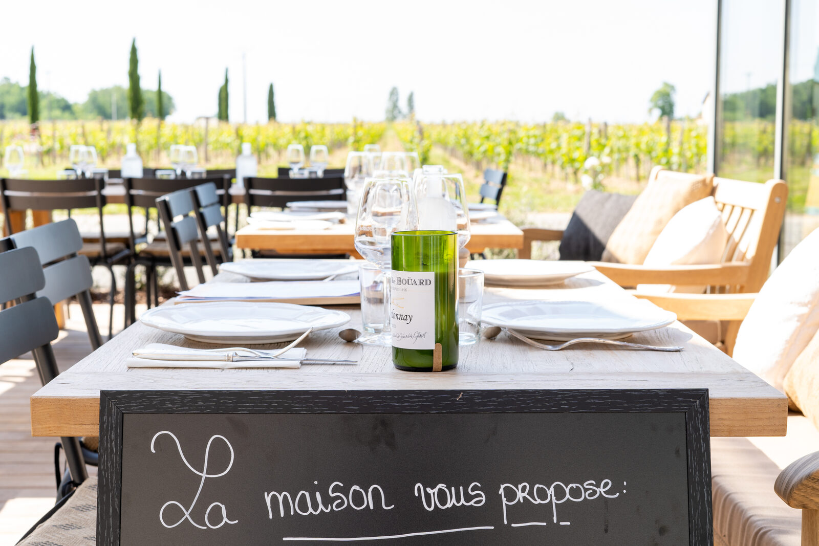 Table dressée face aux vignes avec l'ardoise du menu, rive droite.